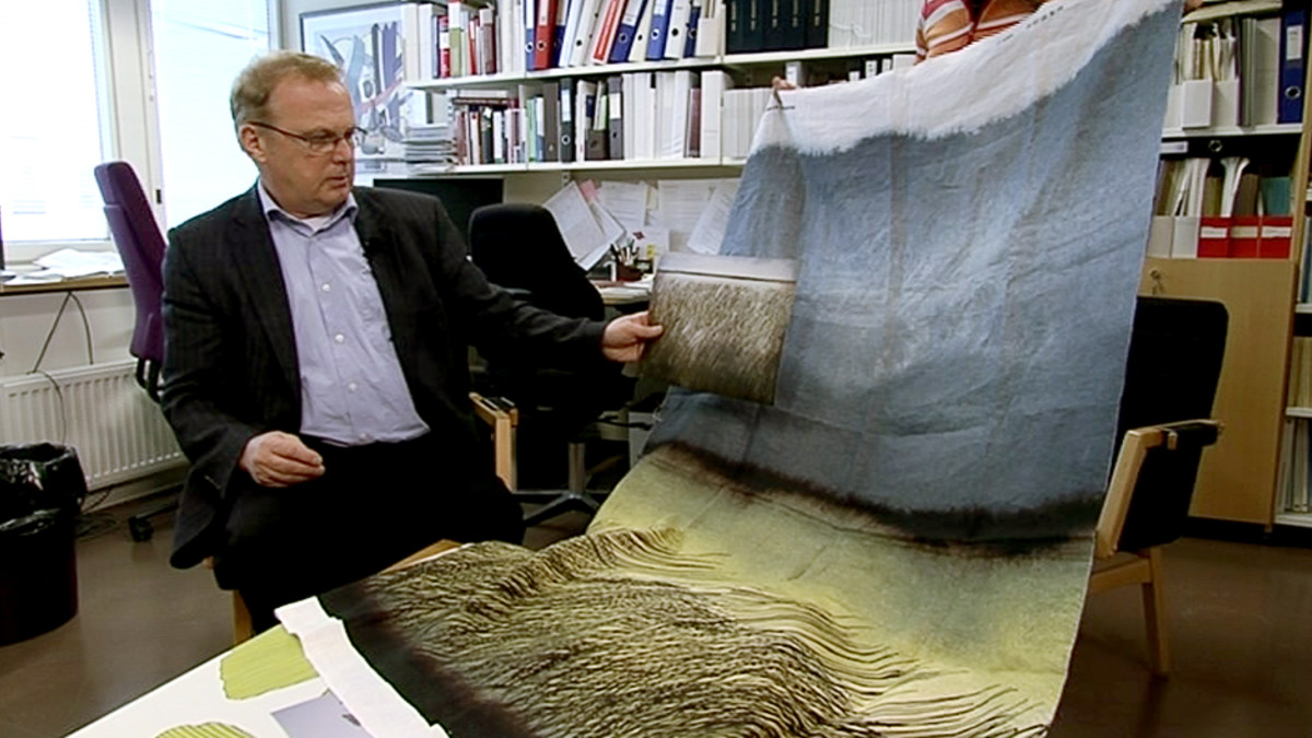 Helsingin yliopiston kauppaoikeuden professori Rainer Oesch vertailemassa Marimekko-kohujen kuvia.