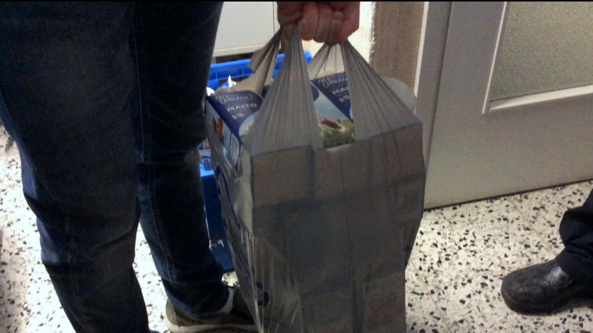 Ostoskassi täynnä maitopurkkeja.