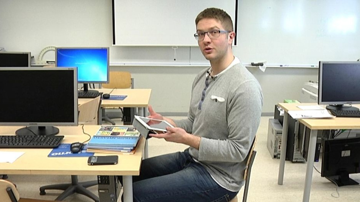 Fysioterapeutti Rasmus Broberg näyttää, millainen on hyvä asento käyttää tablettia tai kännykkää
