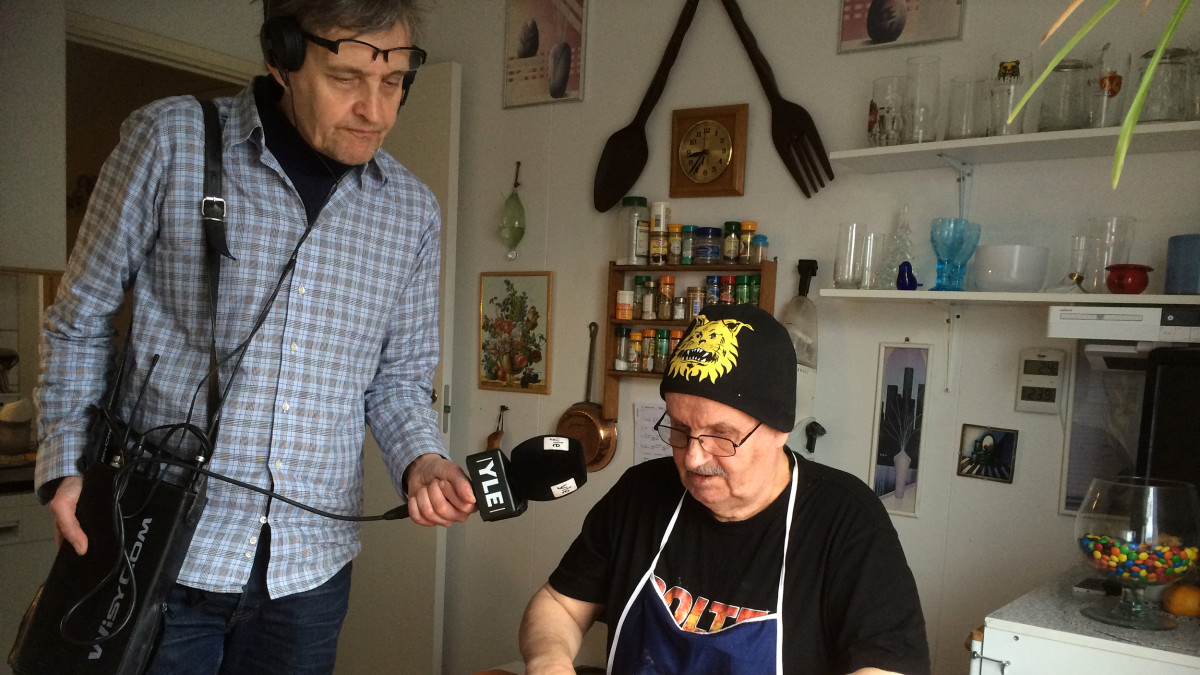 Timo Kurtti leipoo munkkeja ja toimittaja Mauri Tikkamäki haastattelee.