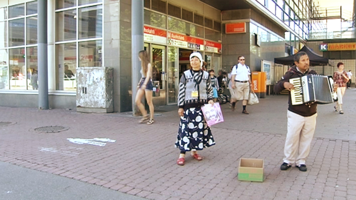 Romanimies soittaa metroaseman edustalla.