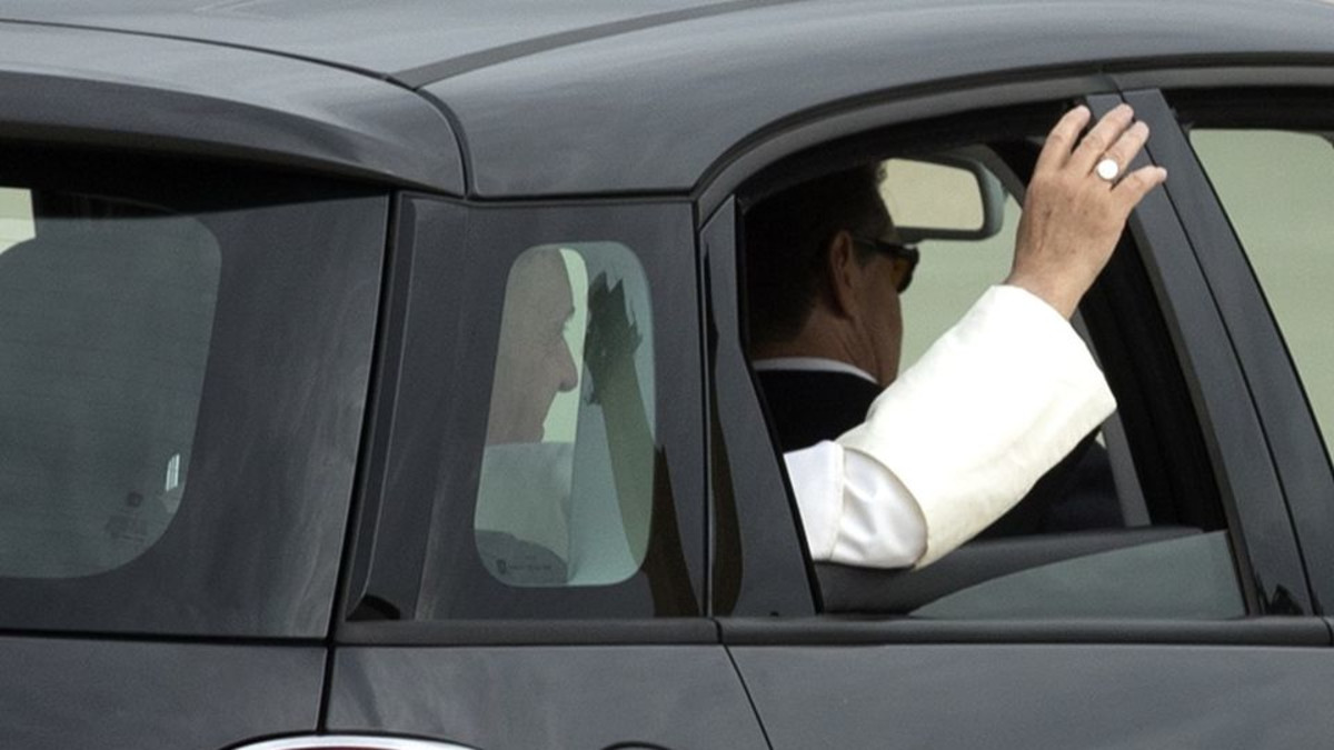 Paavi Francisus vilkuttaa autosta.