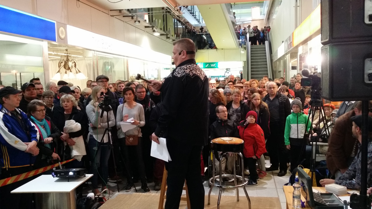 huutokauppameklari ja yleisöä