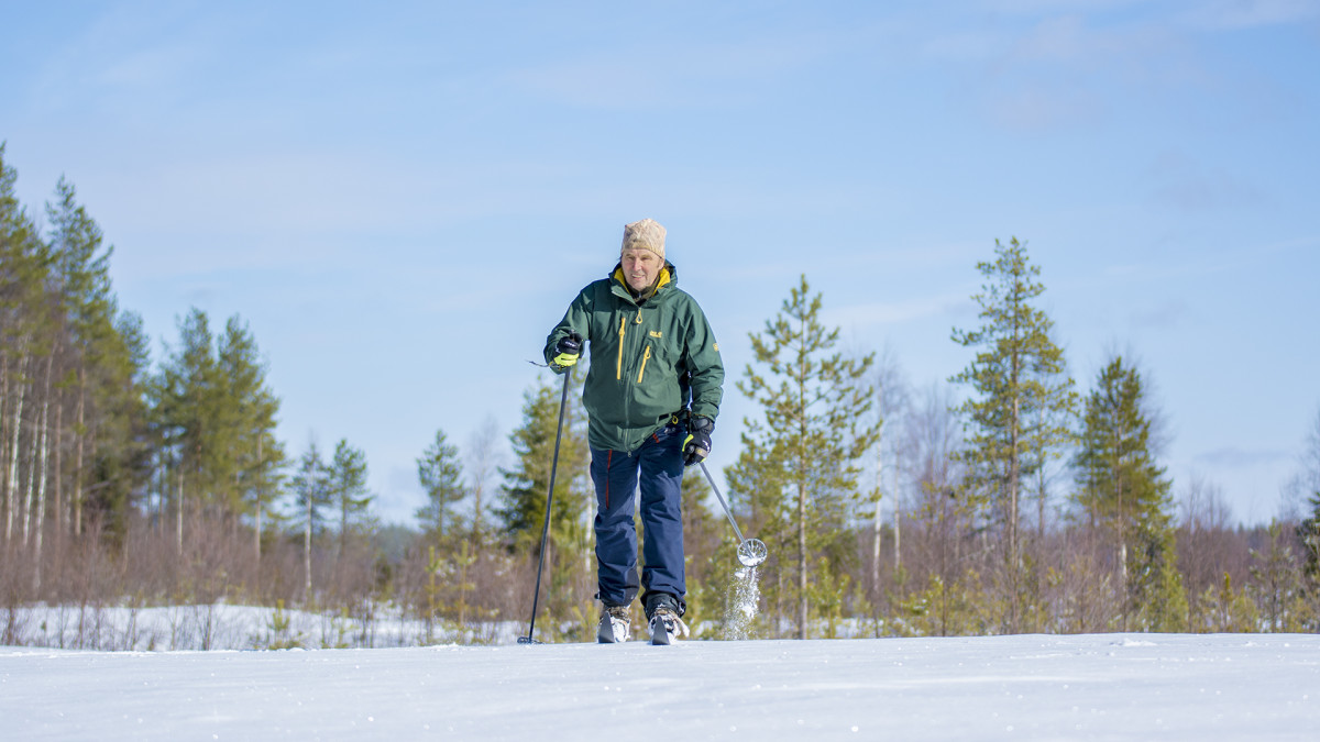 Mies hiihtää pellolla