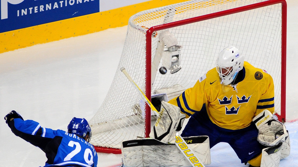 Nokelainen sivaltaa kiekon ohi ruotsalaisvahdin