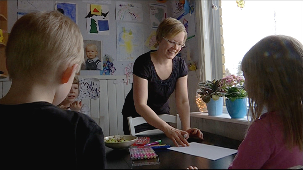 Anne Heikkinen lastensa kanssa kotonaan.