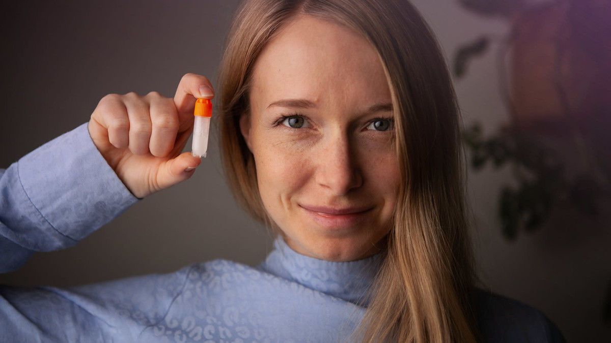Marjut Mäntymaa pitelee kädessään DNA-näytepulloa