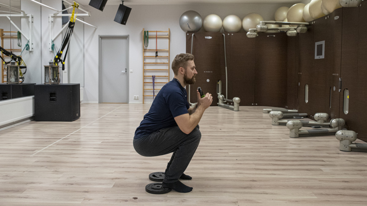 Fysioterapeutti Antti Ruokonen tekemässä kyykyn avustavaa harjoitusta.