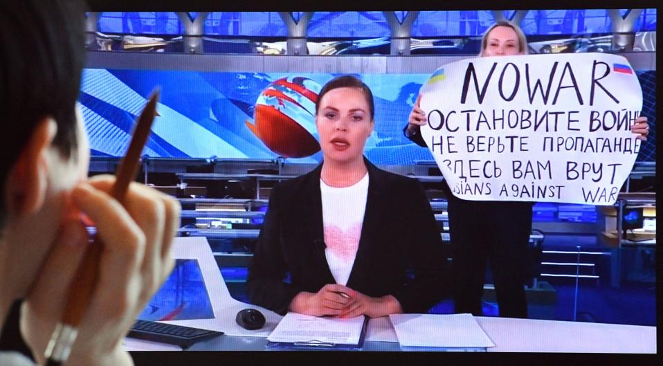 Pervyi Kanalin toimittaja Maria Ovjannikova juoksi 14. maaliskuuta uutislähetyksen taustalle kyltin kanssa, jossa luki