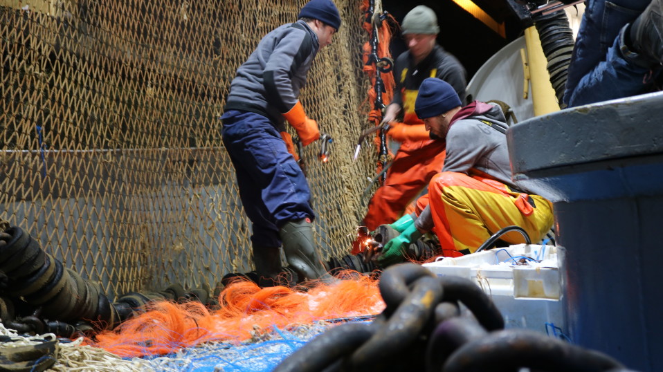 Job Schot nuorempi (vas.) kunnostaa troolia muun miehistön kanssa.