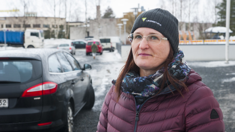 Nainen katsoo kameraa.