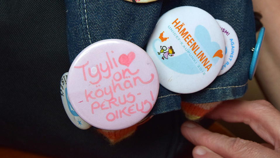 Tyyli on köyhän perusoikeus ja Hämeenlinna -rintanapit lähikuvassa