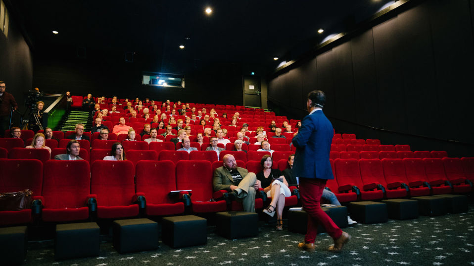 Speakersforumin André Noël Chaker rohkaisee yleisöä ennen elokuvaa voittamaan puhumisenpelkonsa.