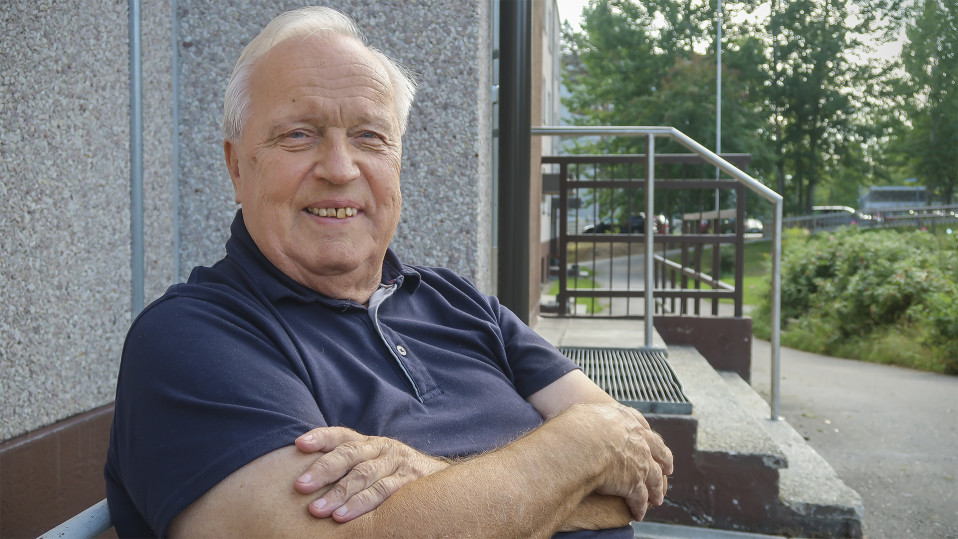 mies hymyilee kameralle