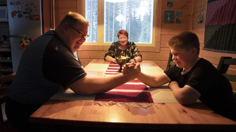 Perhe Laitinen keittiönpöydän ääressä.