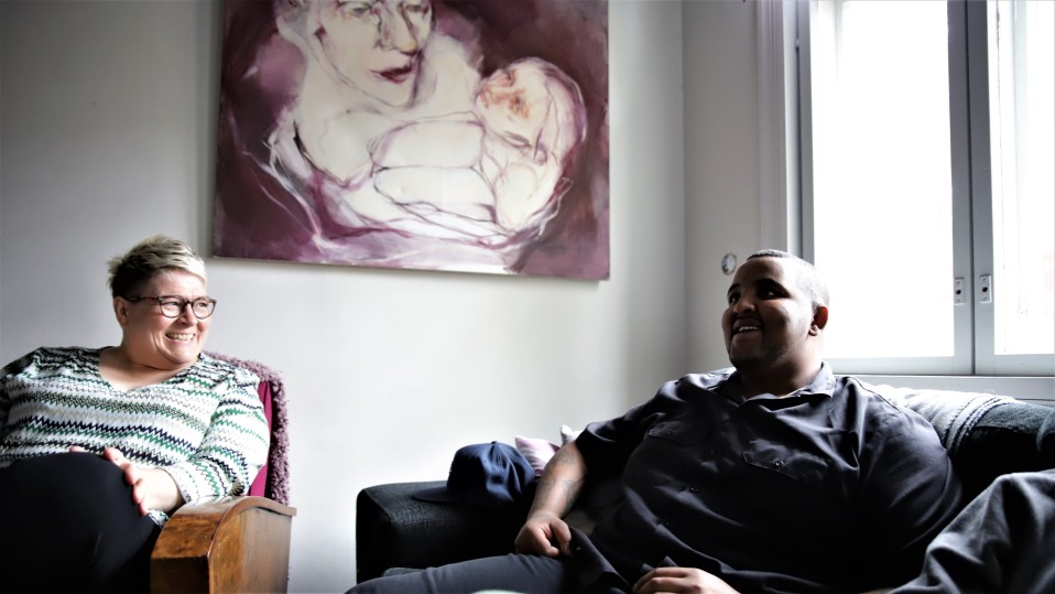 Sari Itäpelto ja Guled Abdi juttelemassa perhekodin olohuoneessa