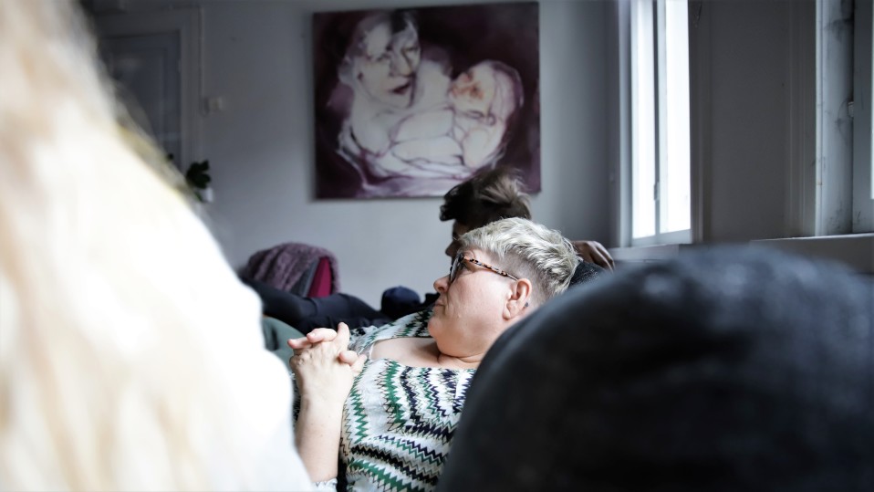 Sari Itäpelto istumassa perhekodin sohvalla