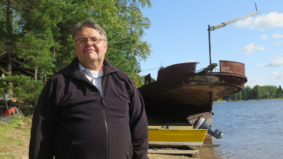 Esko Järvinen seisoo Kuru-laivan ruostuneen rungon edessä