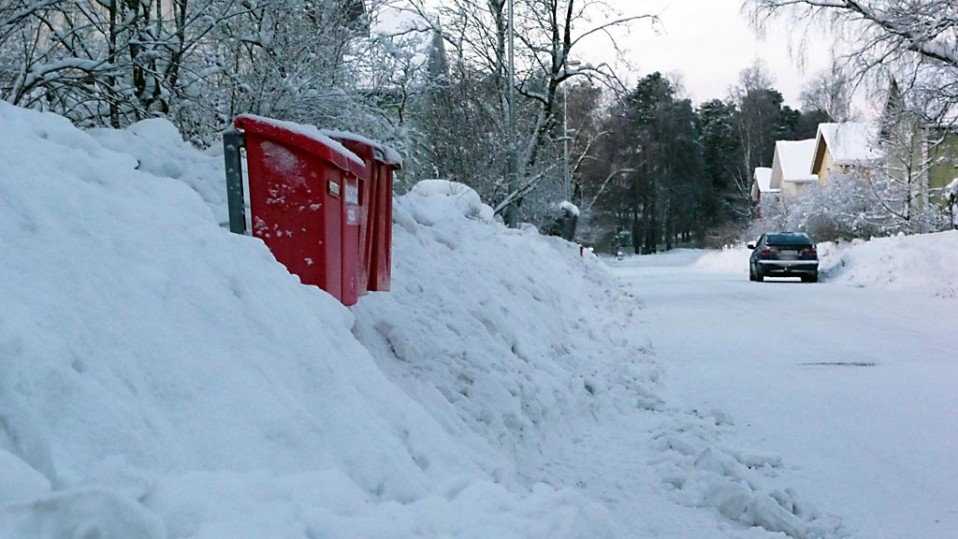 Postilaatikot törröttävät lumikasan keskellä.