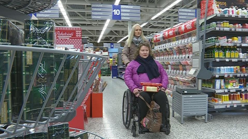 Henkilöhtainen avustaja Hanna Hammarström työntää Marjo Luomasen pyörätuolia kaupassa.