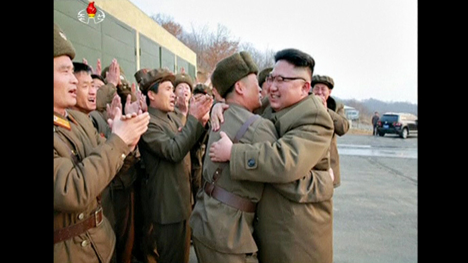 Pohjois-Korean johtaja Kim Jong-un halaa sotilasta. Ympärillä olevat sotilaat osoittavat suosiotaan.