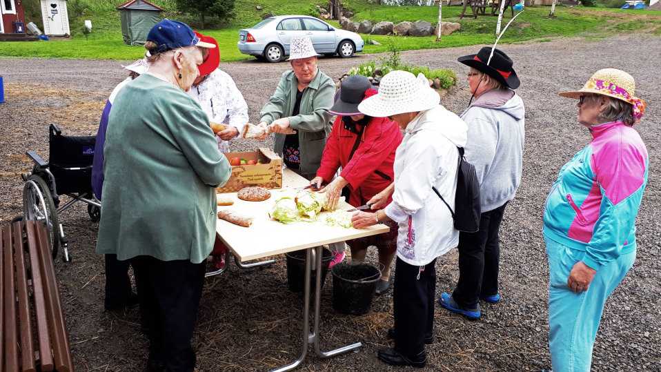 Ihmisiä kokoontuneena pöydän ääreen.