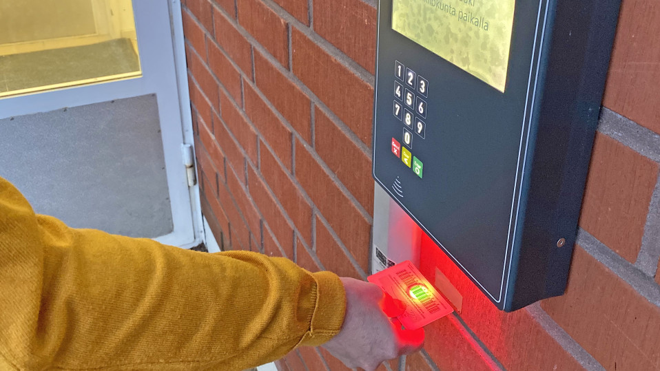 Kuvassa skannataan viivakoodia kirjaston ovella