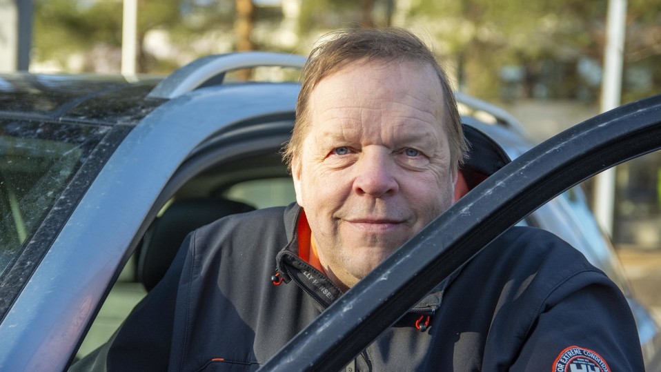 Antti Kela nojaa auton oveen.