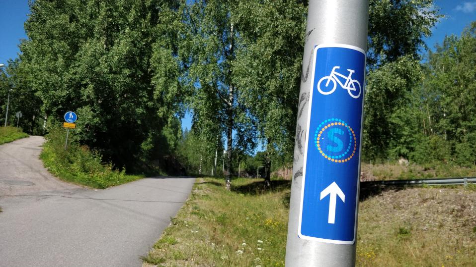 Saimaan saaristoreitin sininen opastetarra on liimattu valotolppaan
