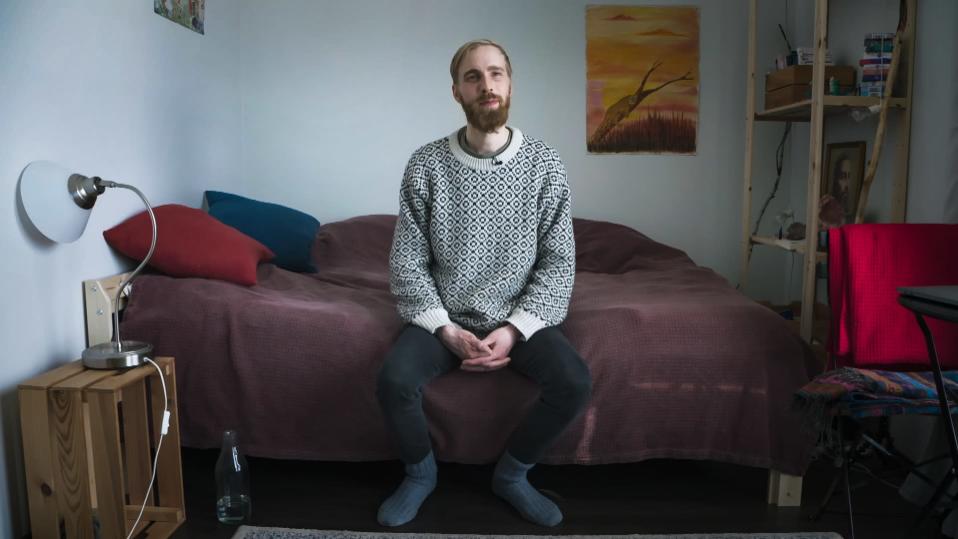 Ville Riipinen istuu sängyn laidalla.
