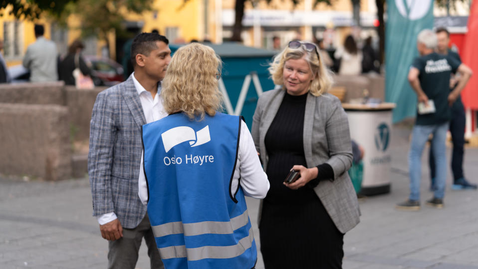 vaalityöntekijä keskustelee ohikulkijoiden kanssa