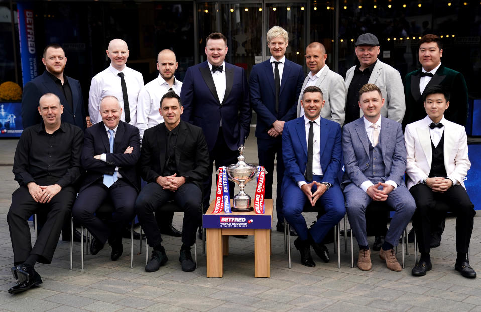 Vuoden 2022 MM-kisojen sijoitetut pelaajat poseerasivat Crucible-teatterin edessä. Etualalla vasemmalta Mark Williams, John Higgins, Ronnie O'Sullivan, Mark Selby, Kyren Wilson ja Zhao Xintong. Ylärivissä vasemmalta alkaen Mark Allen, Anthony McGill, Luca Brecel, Shaun Murphy, Neil Roberton, Barry Hawkins, Stuart Bingham ja Yan Bingtao.