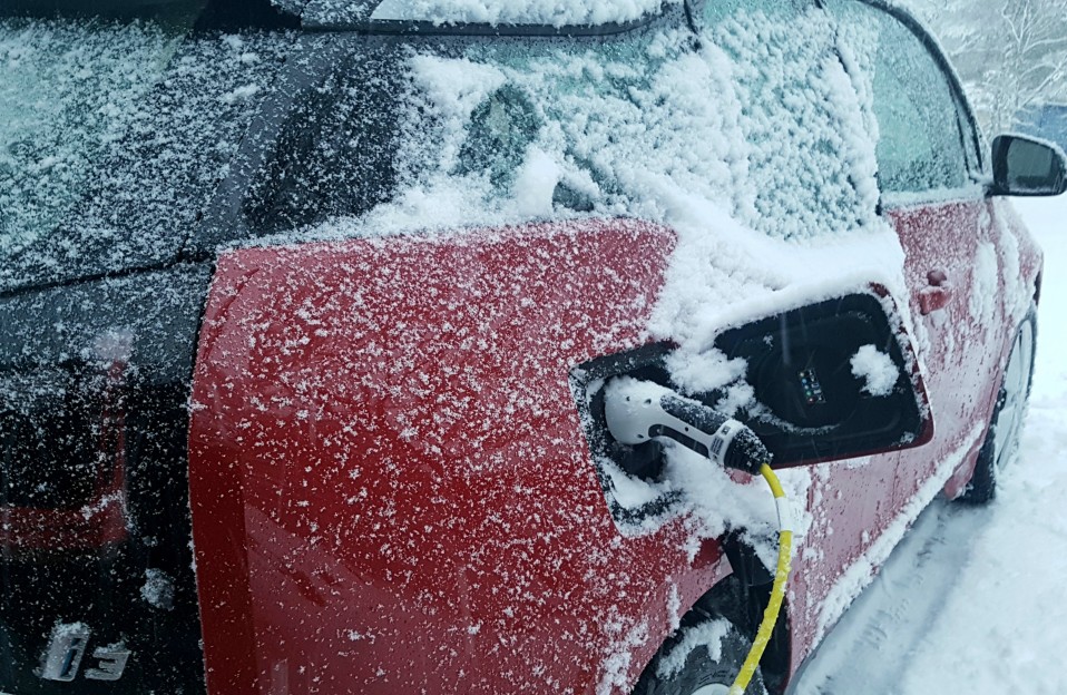 Sähköauton lataus lumisella säällä talvella.