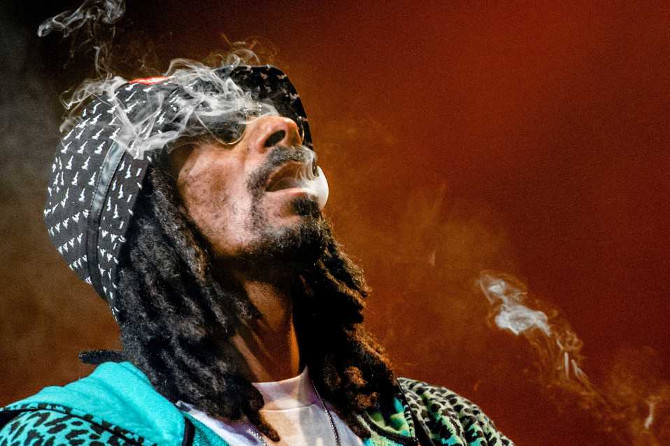 Snoop Dogg låter rök komma ur sin mun.