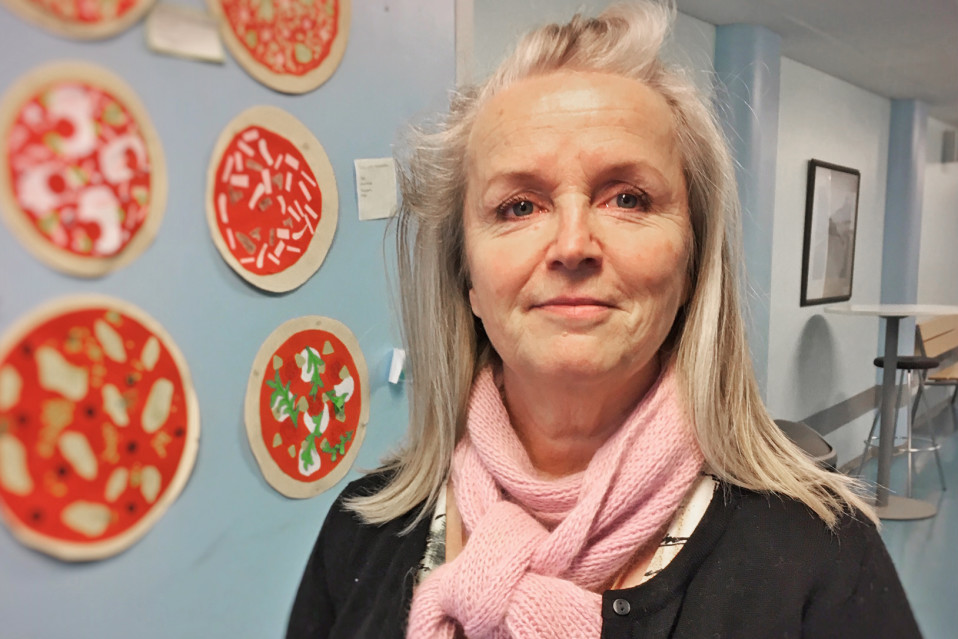 Käsityönopettaja Tiina Tiitinen seisoo koulun käytävällä