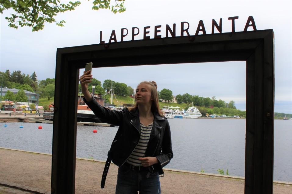 Hanna Muukkonen ottaa itsestään valokuvan Lappeenrannan maisemakehyksissä.