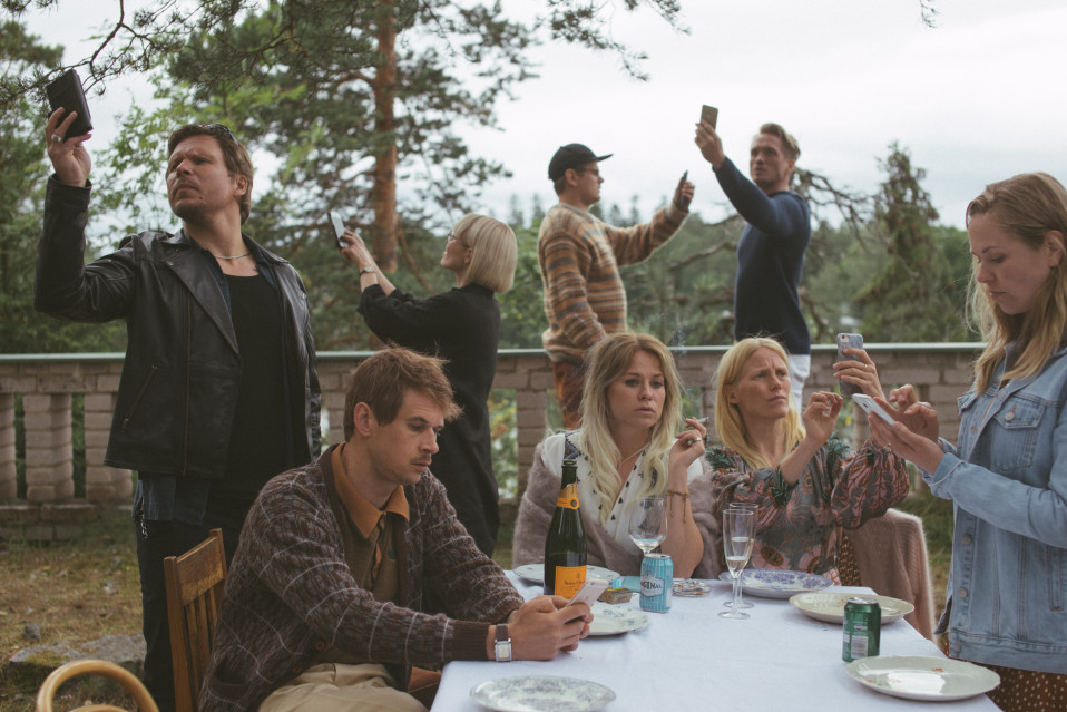 Kuva elokuvasta Seurapeli. Eero Milonoff, Samuli Niittymäki, Paula Vesala, Paavo Kinnunen, Emmi Parviainen, Laura Birn, Christian Hillborg ja Iida-Maria Heinonen. Henkilöt ovat ulkona, ja ottavat selfiekuvia itsestään.