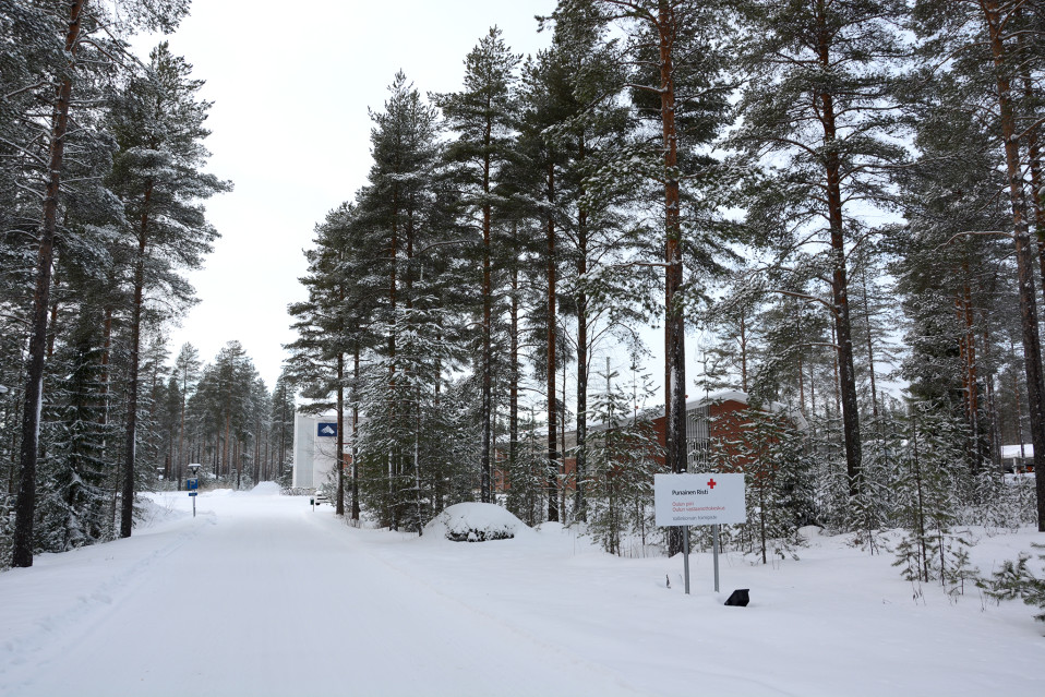 Oulun Vallinkorvan koulurakennus mäntypuiden takana talvella.