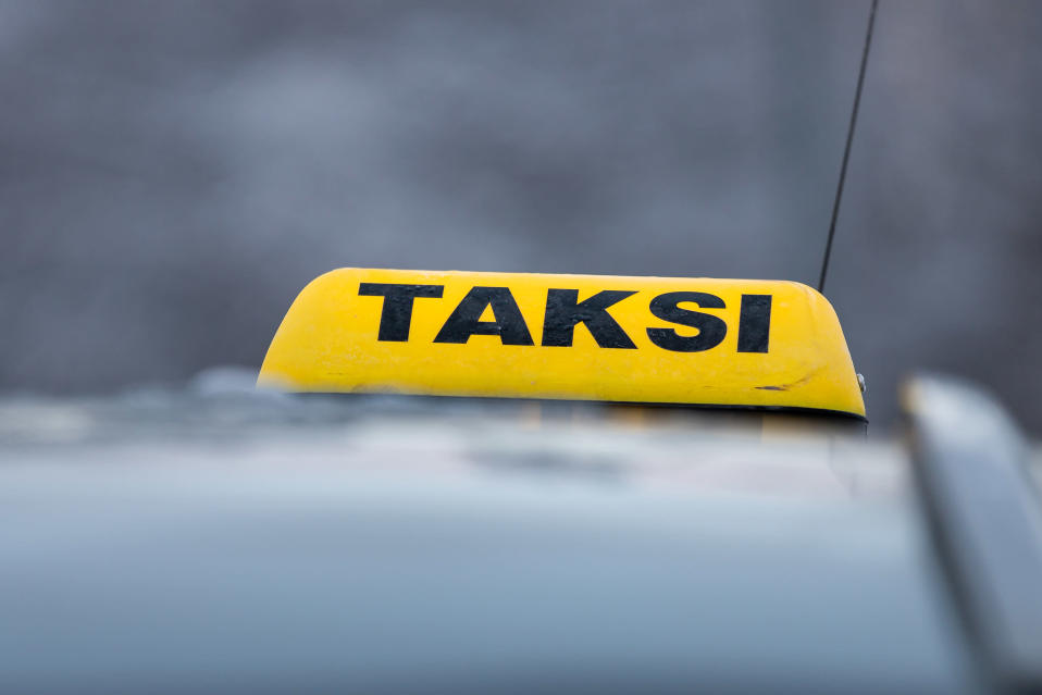 Taxi sign on the roof of the car.