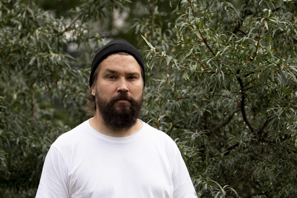 Kirjailija Jukka Viikilä seisoo hopeapajun edessä.