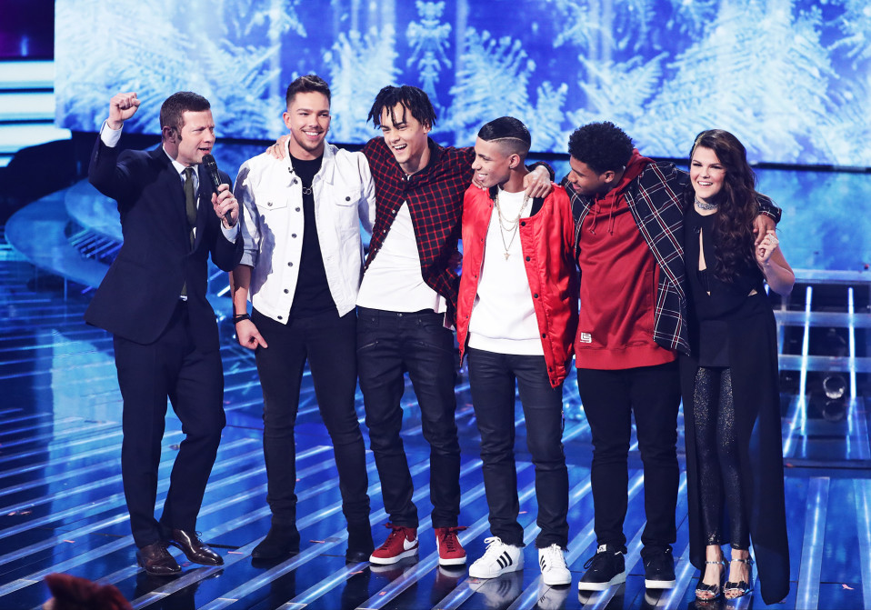 X Factor -ohjelman finalistit vuonna 2016: Matt Terry valkoisessa farkkutakissaan, kolmihenkinen 5 After Midnight -poikabändi ja Saara Aalto. Vasemmalla juontaja Dermot O'Leary.