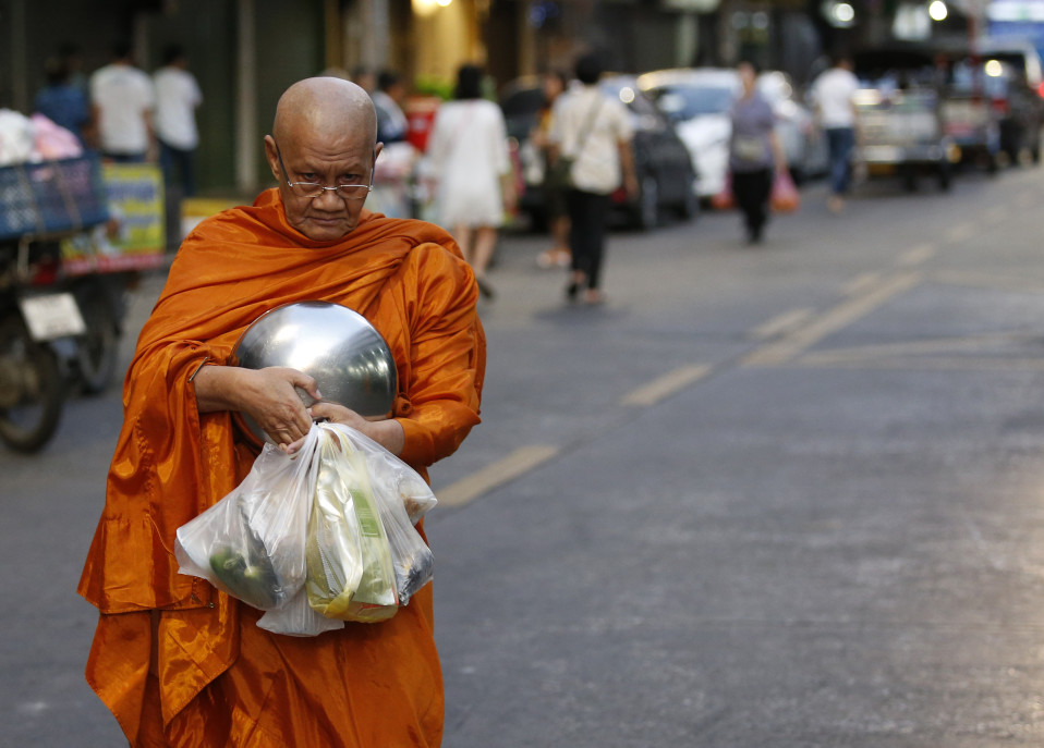 Buddhalaismunkki kantaa saamiaan ruokalahjoituksia.