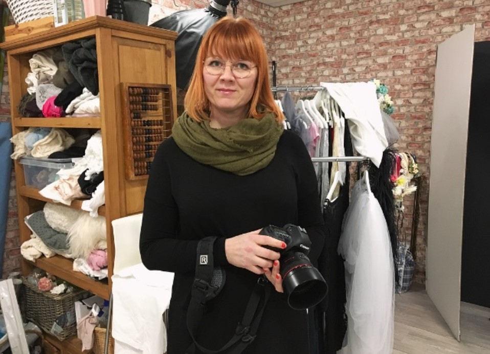 Valokuvaaja Anna-Karoliina Pelto poseeraa kameran kanssa.