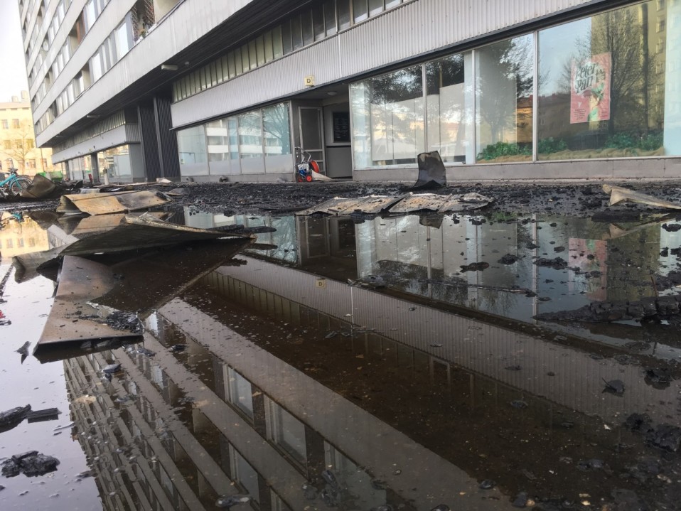 Mustunutta tavaraa kerrostalon edessä.