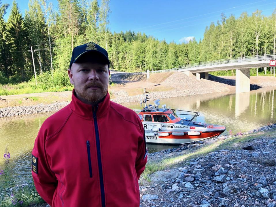 Heinolan järvipelastajien puheenjohtaja Sami Salomaa seisoo Kimolan kanavan varrella takanaan yhdistyksen Kuusakoski -pelastusvene.
