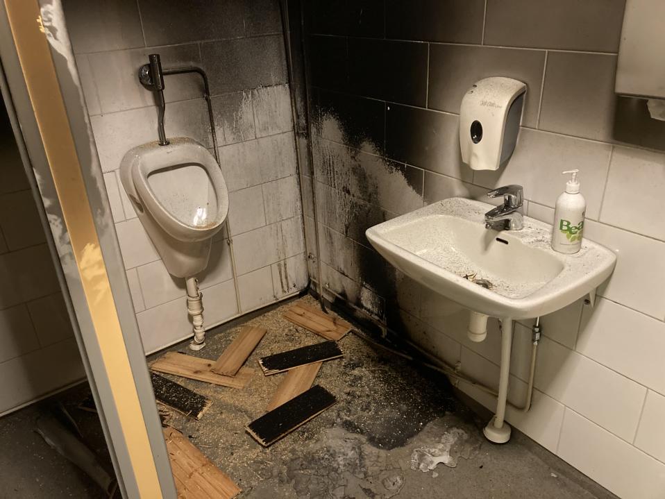 Vessatila, jossa merkkejä tulipalosta. Seinä mustunut, lattialla laudanpaloja.