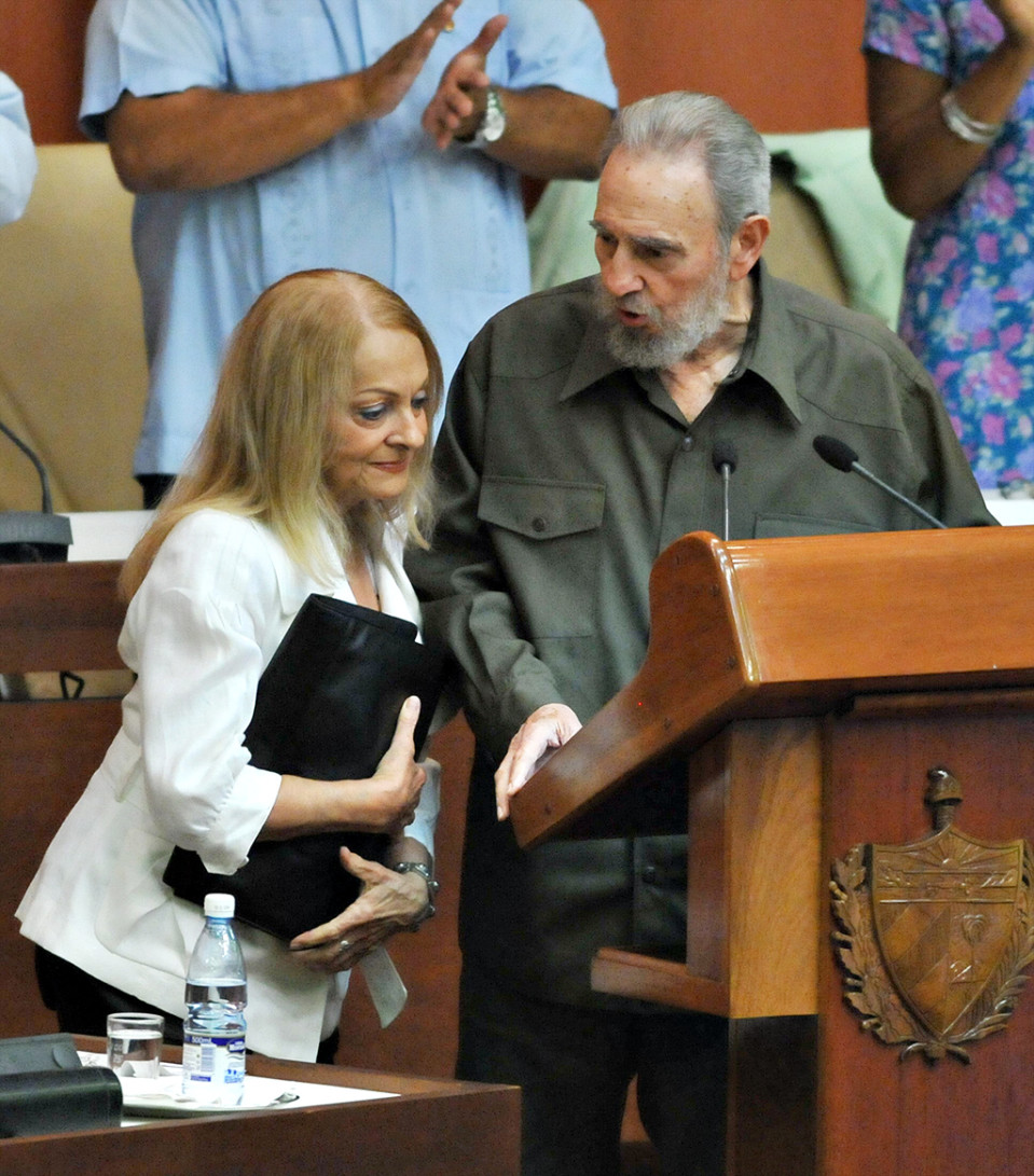 Fidel Castro seisoo puhujakorokkeella Kuuban parlamentissa, vierellään vaimo Dalia Soto de Valle.