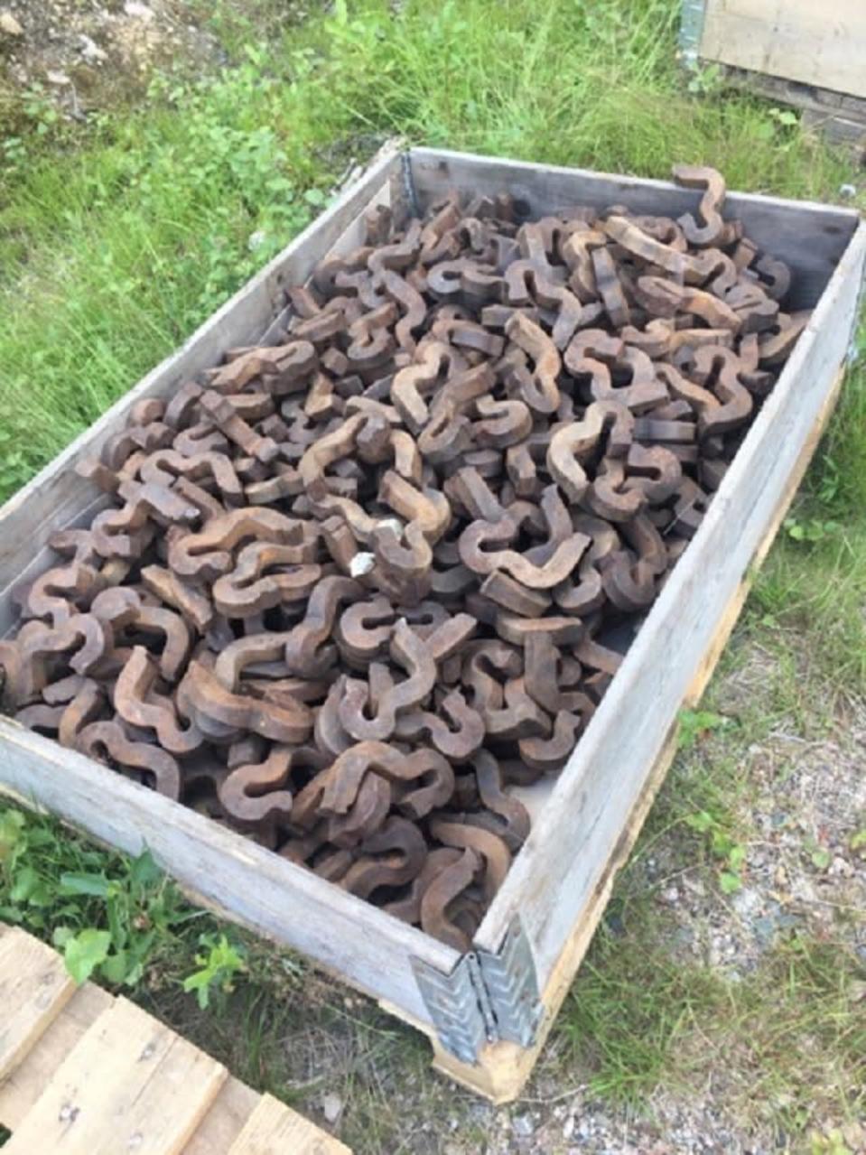 Käyttämättömältä junaradalta irrotettuja kiskoankkureita.