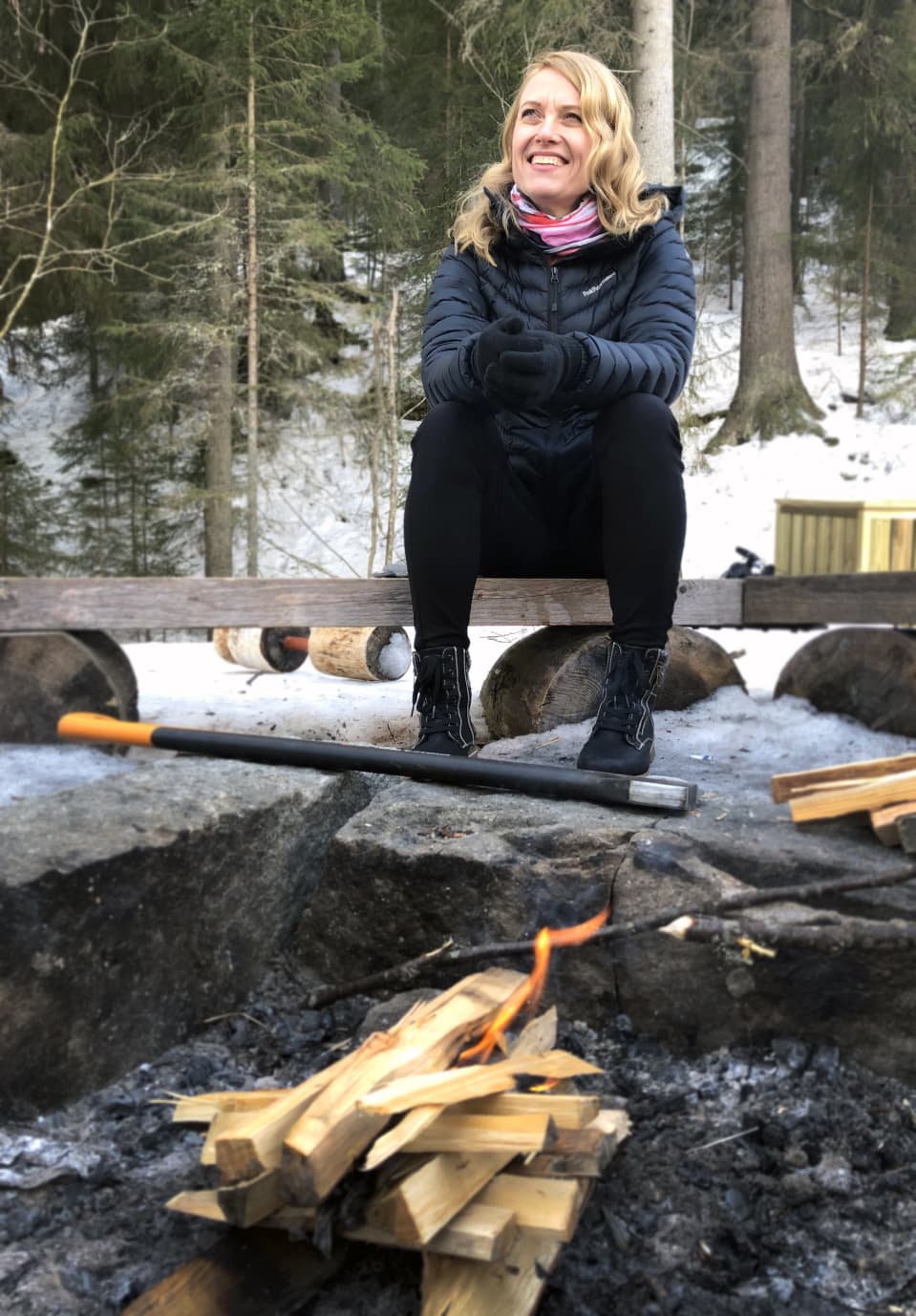 Asikkalan kunnanjohtaja Rinna Ikola-Norrbacka istumassa nuotion ääressä.