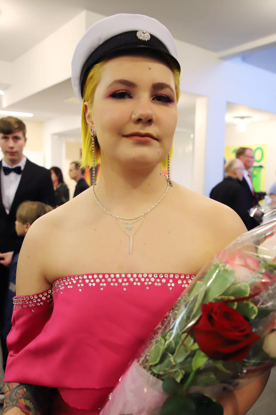 Alisa Vanhatalo valkolakin, ruusujen ja ylioppilastutkintotodistuksen kanssa.